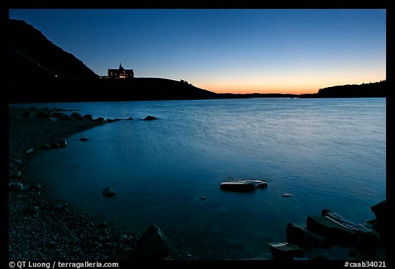 Boulders in Waterton Lake and Prince of Wales hotel, dawn. Waterton Lakes National Park, Alberta, Canada (color)