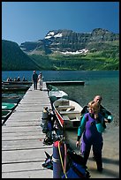 Couple preparing to scuba dive, Cameron Lake. Waterton Lakes National Park, Alberta, Canada