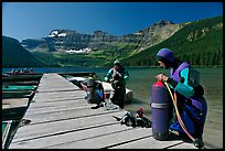 Scuba divers getting ready to dive, Cameron Lake. Waterton Lakes National Park, Alberta, Canada