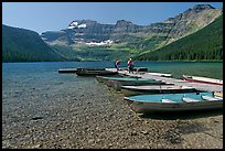 Fishermen walking on dock after unloading a canoe, Cameron Lake. Waterton Lakes National Park, Alberta, Canada