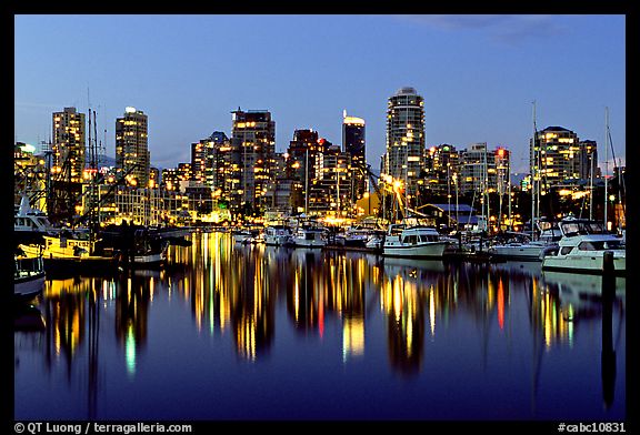 Fishing boats and skyline light reflected at night. Vancouver, British Columbia, Canada