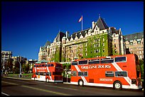 Red double-decker tour busses in front of Empress hotel. Victoria, British Columbia, Canada (color)