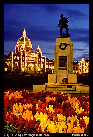 Flowers, memorial statue and illuminated parliament building at night. Victoria, British Columbia, Canada