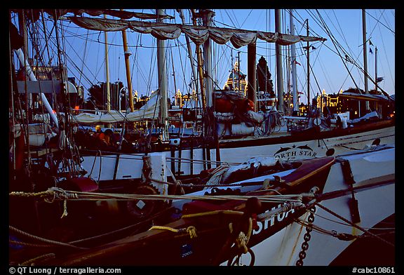 Sailboats with lights of the legislature appearing between masts. Victoria, British Columbia, Canada