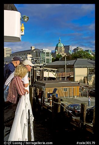 Passengers standing on the deck of the ferry, as it sails into the Inner Harbor. Victoria, British Columbia, Canada (color)