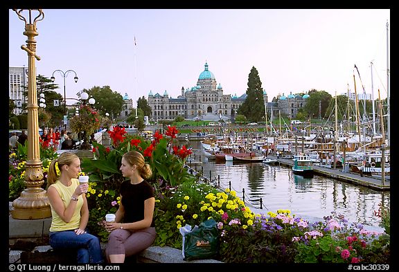 Women drinking coffee at the Inner Harbour, sunset. Victoria, British Columbia, Canada