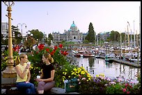 Women drinking coffee at the Inner Harbour, sunset. Victoria, British Columbia, Canada (color)