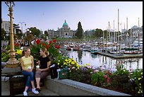 Young Women sitting, Inner harbor. Victoria, British Columbia, Canada