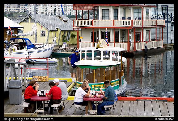 People eating fish and chips on deck,  Fisherman's wharf. Victoria, British Columbia, Canada