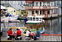 People eating fish and chips on deck,  Fisherman's wharf. Victoria, British Columbia, Canada (color)