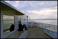 Passenger sitting on the deck of ferry. Vancouver Island, British Columbia, Canada (color)