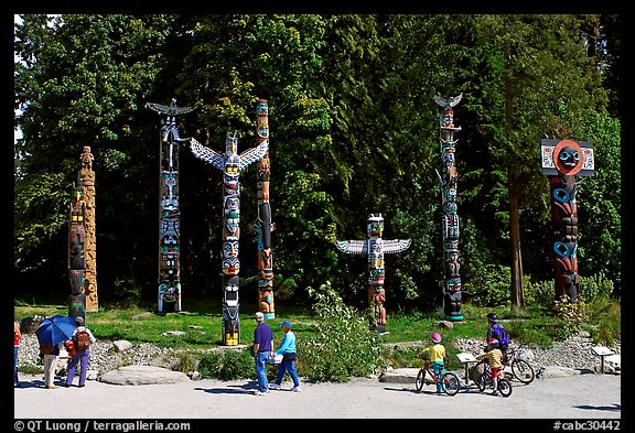 Tourists loooking at Totems, Stanley Park. Vancouver, British Columbia, Canada (color)