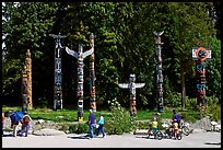 Tourists loooking at Totems, Stanley Park. Vancouver, British Columbia, Canada