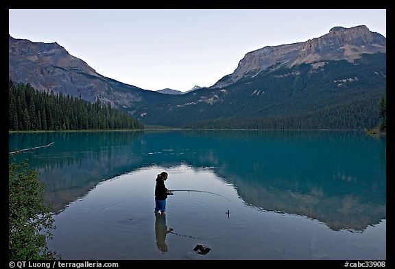 Woman fishing in Emerald Lake, sunset. Yoho National Park, Canadian Rockies, British Columbia, Canada