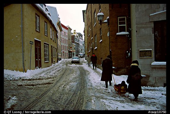 Residents pulling a sled with a child in a street, Quebec City. Quebec, Canada