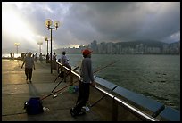 Fishing on the waterfront promenade, sunrise. Hong-Kong, China