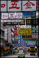 Busses in a street filled up with signs in Chinese, Kowloon. Hong-Kong, China