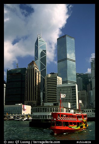 Ferry leaves a pier on Hong-Kong Island. Its symmetrical shape alleviates the need for turning around. Hong-Kong, China (color)