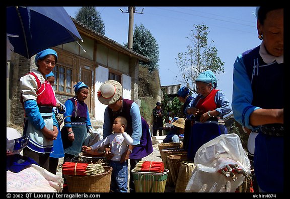 Women of Bai hill tribe offering incense for sale. Shaping, Yunnan, China