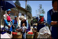 Women of Bai hill tribe offering incense for sale. Shaping, Yunnan, China