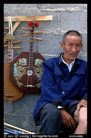 Man selling musical instruments. Shaping, Yunnan, China (color)