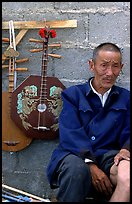 Man selling musical instruments. Shaping, Yunnan, China (color)