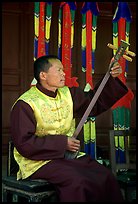 Musician playing a three-stringed traditional moon guitar. Baisha, Yunnan, China