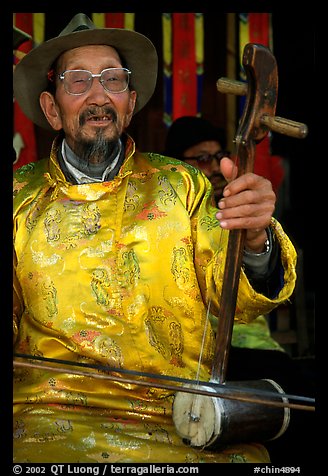 Elderly musician playing the traditional two-stringed Ehru. Baisha, Yunnan, China (color)