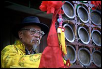 Elderly  musician playing a traditional percussion instrument. Baisha, Yunnan, China ( color)