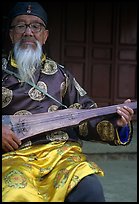 Elderly musician playing the a traditional guitar. Baisha, Yunnan, China ( color)