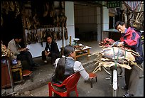 Loading roasted meat on a bicycle. Kunming, Yunnan, China