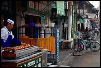 Muslim cook at restaurant storefront. Kunming, Yunnan, China (color)