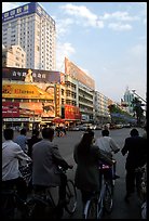 Bicyclists wait for the green light on a modern avenue. Kunming, Yunnan, China ( color)