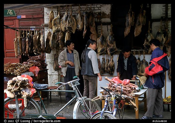 Loading roasted meat on a bicycle. Kunming, Yunnan, China