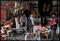 Loading roasted meat on a bicycle. Kunming, Yunnan, China (color)