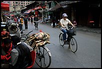 Woman on bicycle in an old backstreet. Kunming, Yunnan, China (color)