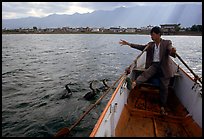 Cormorant Fisherman gives orders to his  fishing birds. Dali, Yunnan, China