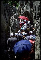 Crowds of Chinese tourists in a walkway among the limestone pillars. Shilin, Yunnan, China