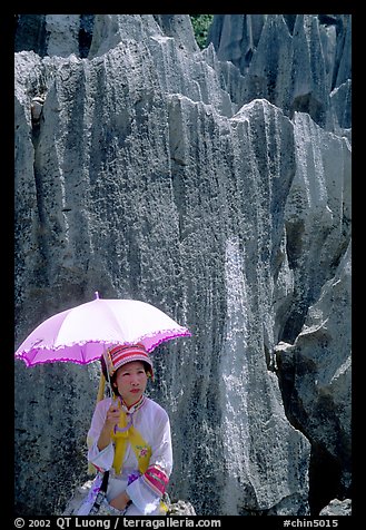 Woman from the Sani branch of the Yi tribespeople with a sun unbrella at the Stone Forest. Shilin, Yunnan, China