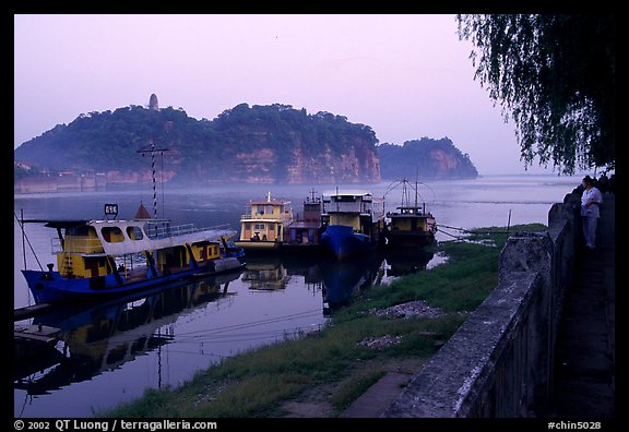 Boats along the river with cliffs in the background. Leshan, Sichuan, China (color)