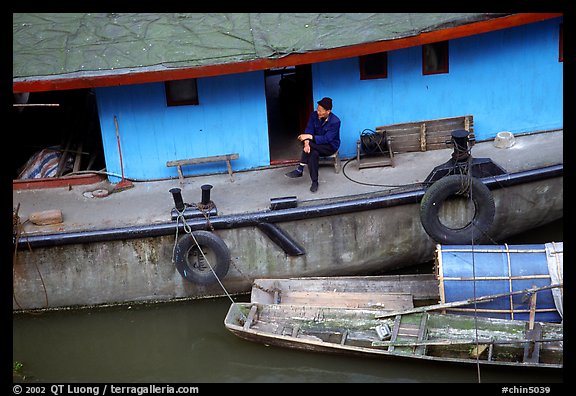 Man sitting on a house boat. Leshan, Sichuan, China (color)