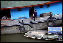 Man sitting on a house boat. Leshan, Sichuan, China