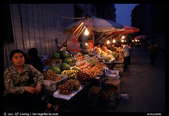 Fruit vendor, night market. Leshan, Sichuan, China