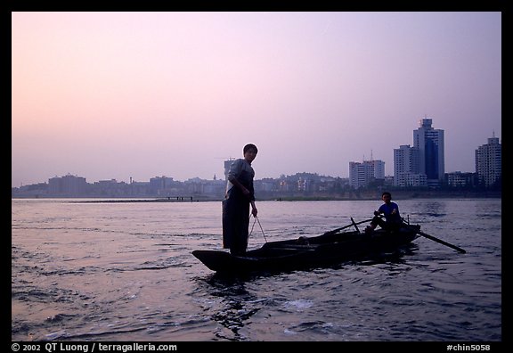 Fishermen at the confluence of the Dadu He and Min He rivers at sunset. Leshan, Sichuan, China