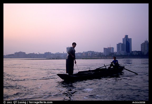 Fishermen at the confluence of the Dadu He and Min He rivers at sunset. Leshan, Sichuan, China (color)