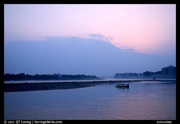 Boat at the confluence of the Dadu He and Min He rivers at sunset. Leshan, Sichuan, China (color)