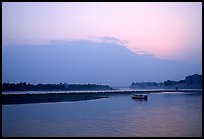 Boat at the confluence of the Dadu He and Min He rivers at sunset. Leshan, Sichuan, China