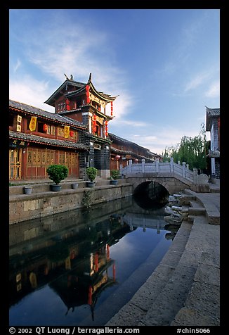 Kegong tower (memorial archway of imperial exam) reflected in canal, sunrise. Lijiang, Yunnan, China