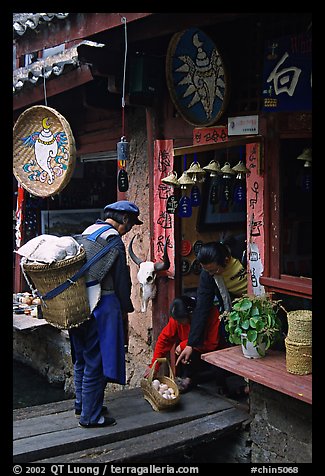 Naxi woman offers eggs for sale to local residents. Lijiang, Yunnan, China (color)