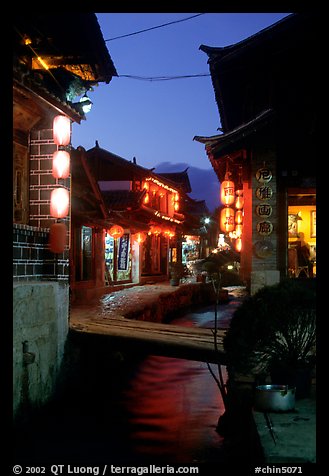 Streets, bridge, wooden houses, red lanterns and canal. Lijiang, Yunnan, China (color)